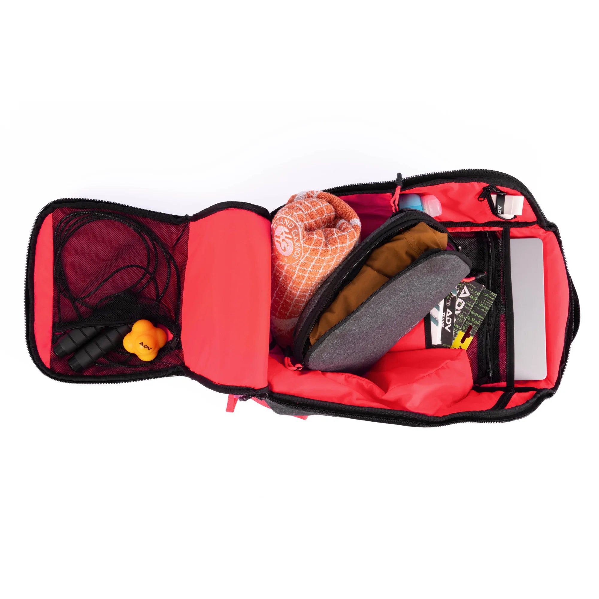 Open tennis bag with bright red interior, featuring organized compartments holding a towel, jump rope, laptop, and accessories.