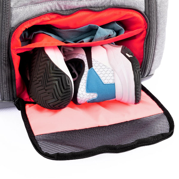 Tennis backpack with shoe compartment shown open with sneakers and clothes inside, featuring a ventilated mesh flap and bright interior lining for organized, odor-contained storage.