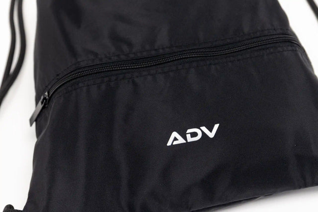 Close-up of the black ADV drawstring bag highlighting the white logo and zippered front pocket.