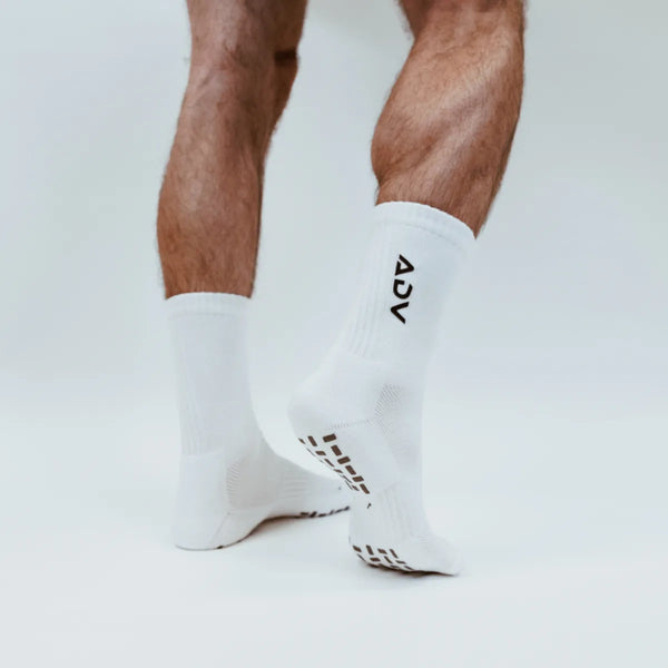 White ADV Pro crew socks showing grip pattern on the sole for court play.
