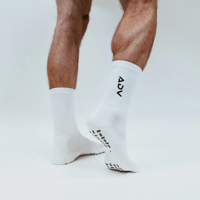 White ADV Pro crew socks showing grip pattern on the sole for court play.