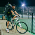 Pro tennis bag carried by a cyclist, designed for athletes needing spacious, durable storage for rackets and gear.