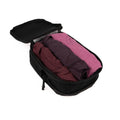 Black ADV packing cube open and filled with rolled purple and pink clothing.