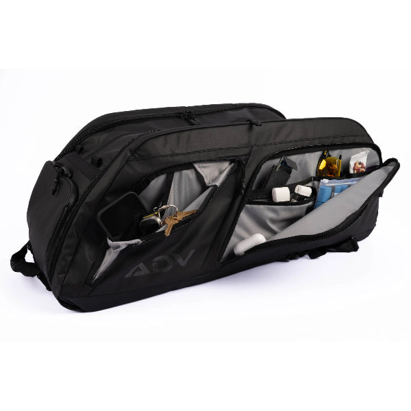 Black tennis racquet bag with multiple compartments open to reveal organized accessories including keys, sunglasses, and grooming items.