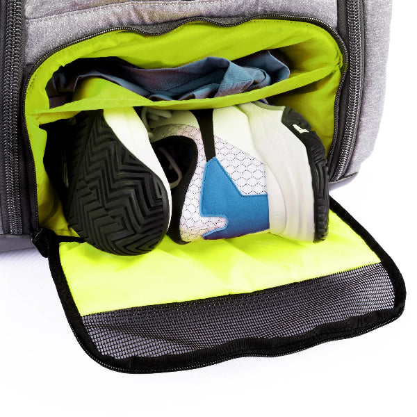 Tennis backpack with shoe compartment shown open, storing athletic shoes and clothes inside a ventilated section.