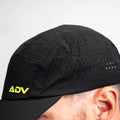 Black ADVantage tennis cap with volt logo and laser-perforated venting, worn on-model.