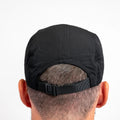 Rear view of black ADVantage tennis cap showing adjustable strap on a person's head.