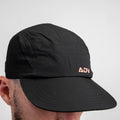 Black ADVantage tennis cap with coral logo and perforated side panel, worn on-model.