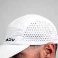 White ADVantage tennis cap worn on head, showing perforated side panel and black ADV logo.