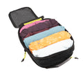 Open ADV medium packing cube filled with folded clothes, volt-green zipper pulls.