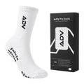 White ADV Pro Tennis Sock in size M with grip sole displayed next to its black retail packaging.
