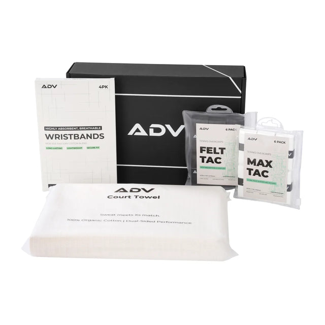 ADV tennis accessories kit: wristbands, overgrips, and court towel beside a black gift box.